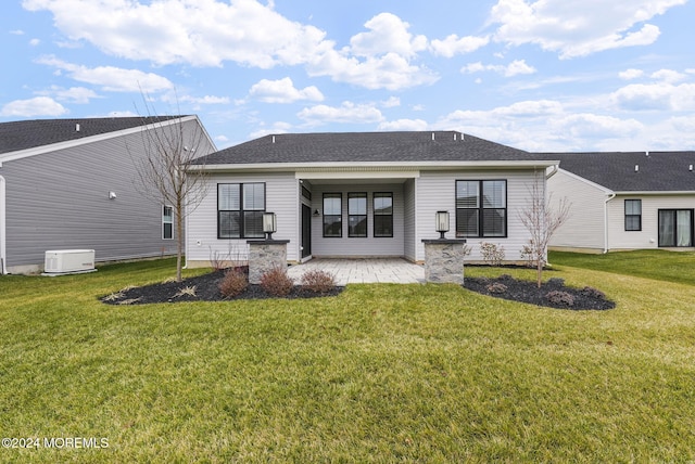 rear view of property featuring a yard and a patio