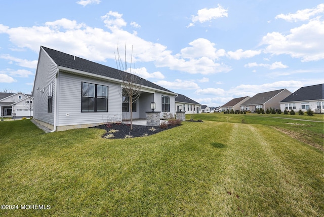 rear view of house featuring a yard and a patio