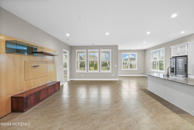 unfurnished living room with sink and light tile patterned floors