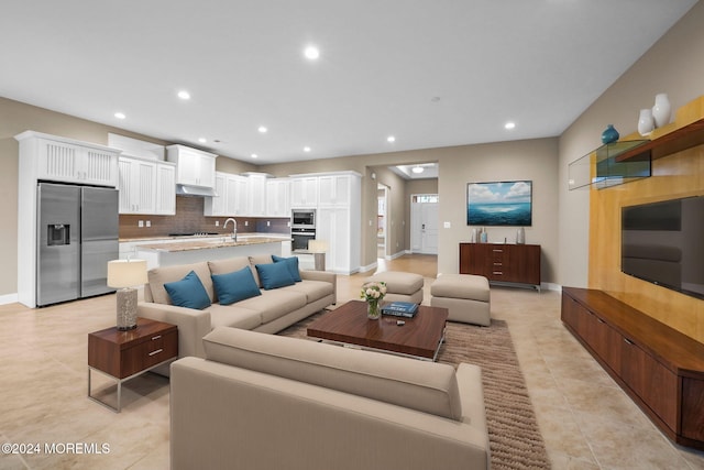 living room featuring sink and light tile patterned floors