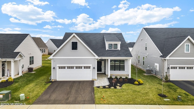 view of front of house featuring a front yard, central AC, and a garage