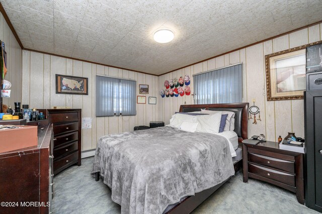 carpeted bedroom featuring wooden walls and a baseboard heating unit