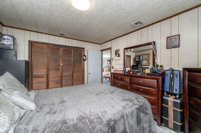 bedroom with crown molding, a closet, and wooden walls