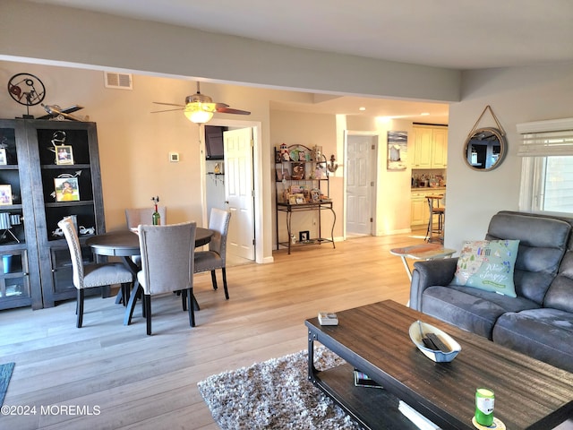 living room with light hardwood / wood-style flooring and ceiling fan