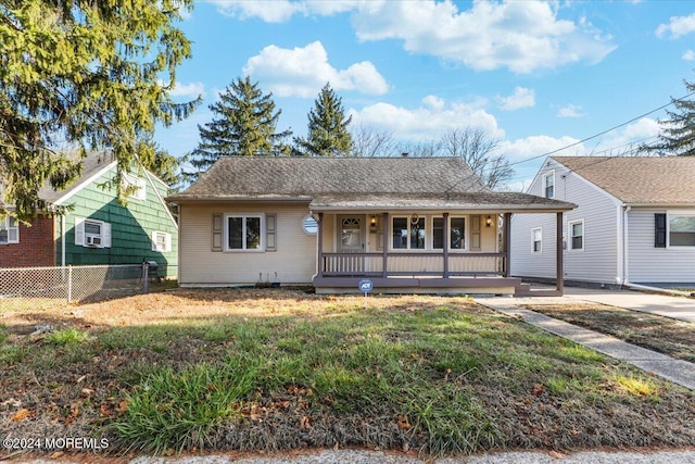 bungalow-style home with covered porch and a front yard