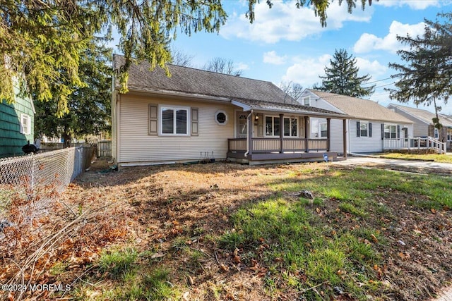 ranch-style house featuring a front yard and a deck