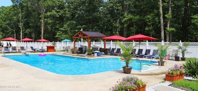 view of pool featuring a gazebo, a diving board, and a patio area