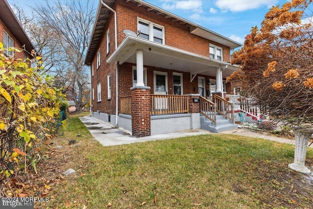 view of front of home with covered porch and a front yard