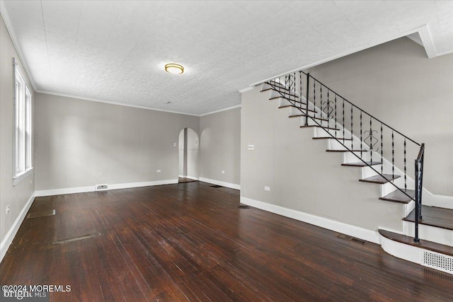 unfurnished living room featuring wood-type flooring and ornamental molding