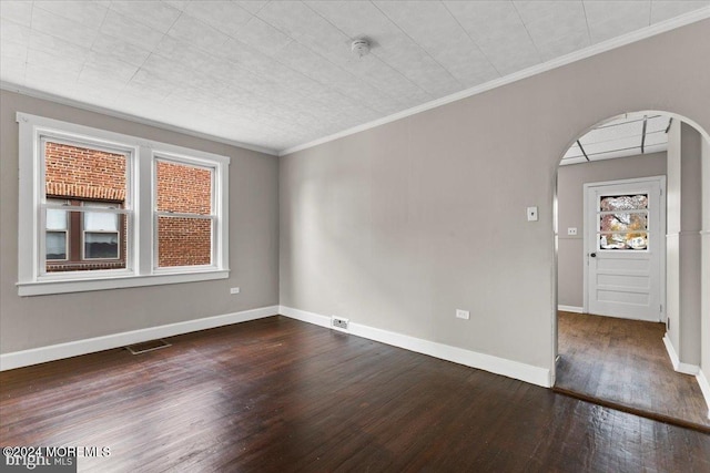 unfurnished room with crown molding and dark wood-type flooring