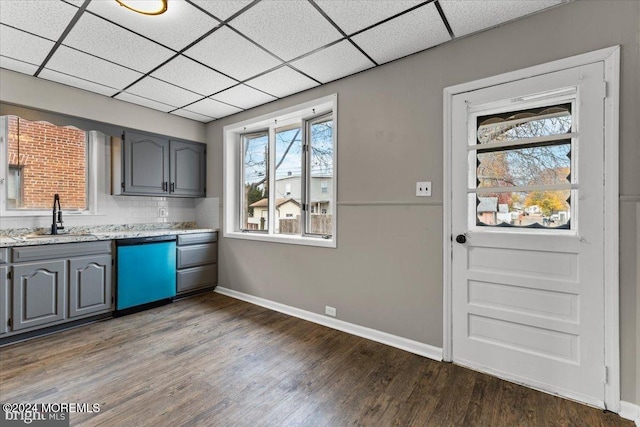 kitchen featuring gray cabinetry, a drop ceiling, dark wood-type flooring, sink, and stainless steel dishwasher