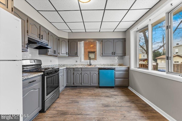 kitchen with sink, stainless steel appliances, dark hardwood / wood-style flooring, gray cabinets, and decorative backsplash