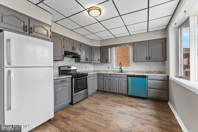 kitchen featuring a paneled ceiling, backsplash, dark wood-type flooring, sink, and stainless steel appliances