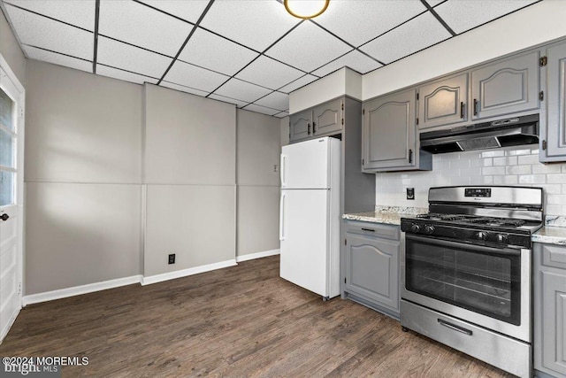 kitchen featuring backsplash, gray cabinetry, white fridge, stainless steel range with gas cooktop, and dark hardwood / wood-style floors