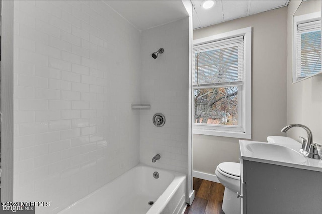 full bathroom featuring toilet, vanity, tiled shower / bath combo, and hardwood / wood-style flooring