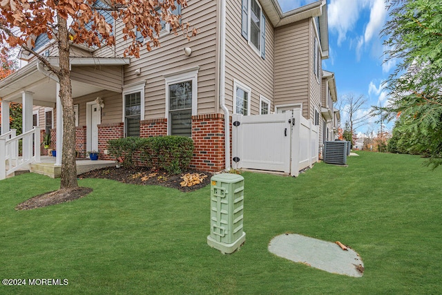 view of side of property featuring a lawn and central AC unit