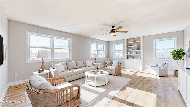 living room with ceiling fan, light wood finished floors, and baseboards