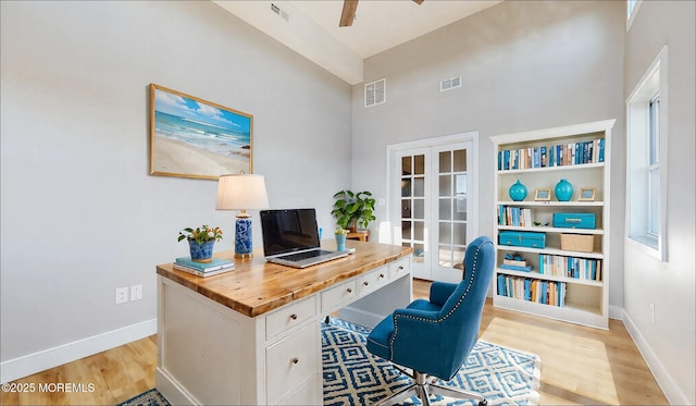 office space with visible vents, light wood-style flooring, and baseboards