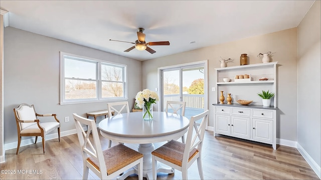 dining space with light wood-style flooring, baseboards, and a ceiling fan