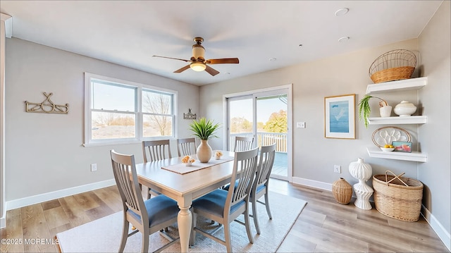 dining area with baseboards, a ceiling fan, and light wood-style floors