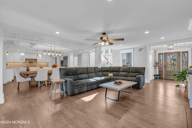 living room with ceiling fan, ornamental molding, and hardwood / wood-style flooring