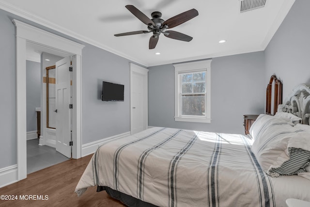 bedroom with ceiling fan, crown molding, ensuite bathroom, and hardwood / wood-style flooring