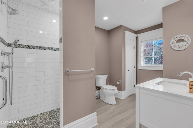 bathroom featuring vanity, wood-type flooring, a shower with shower door, and toilet