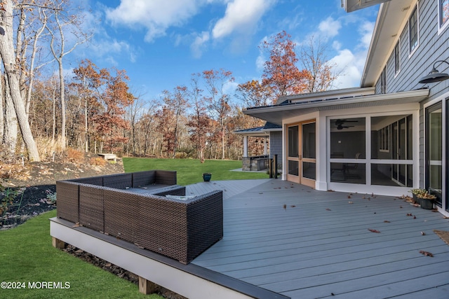 deck featuring a sunroom, a yard, and outdoor lounge area