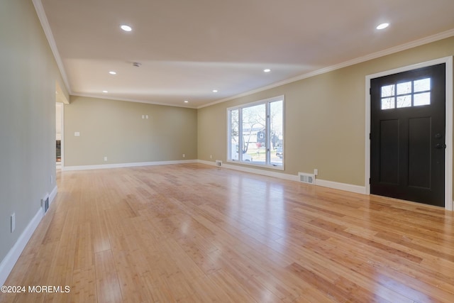 entrance foyer with light wood-type flooring, a wealth of natural light, and crown molding