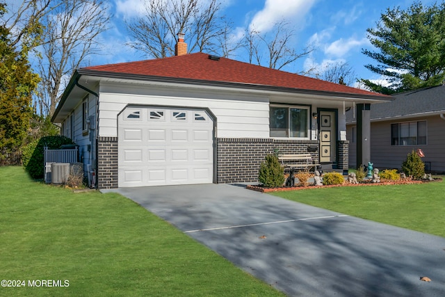 ranch-style house featuring cooling unit, a garage, and a front lawn