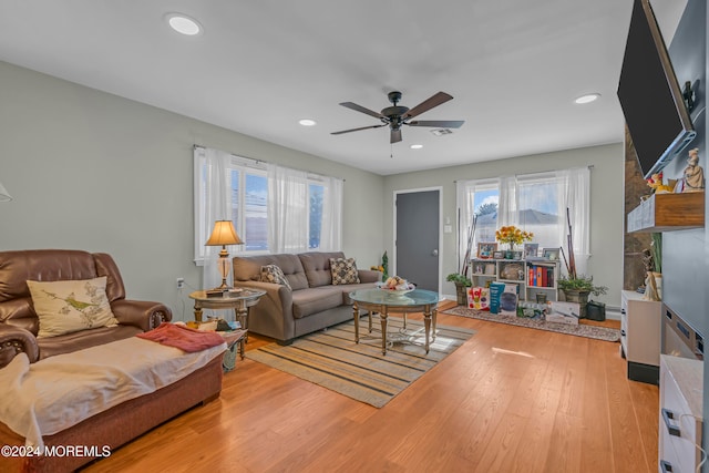 living room with ceiling fan and light hardwood / wood-style flooring