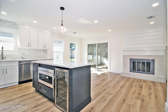 kitchen featuring dishwasher, light hardwood / wood-style floors, white cabinetry, and plenty of natural light