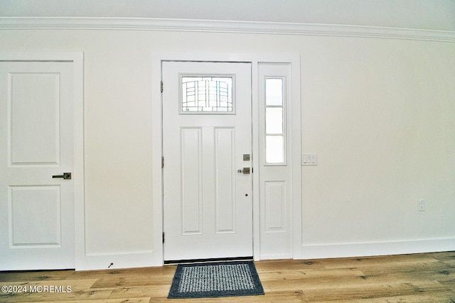 foyer entrance featuring wood-type flooring and crown molding