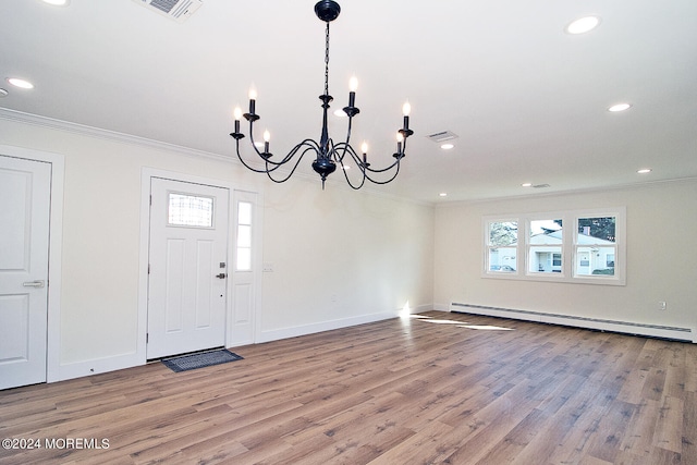 entryway with a baseboard radiator, hardwood / wood-style flooring, crown molding, and a notable chandelier