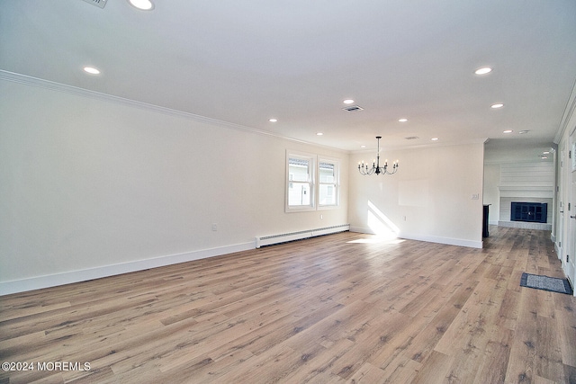 unfurnished living room with ornamental molding, a baseboard heating unit, a notable chandelier, a fireplace, and light hardwood / wood-style floors