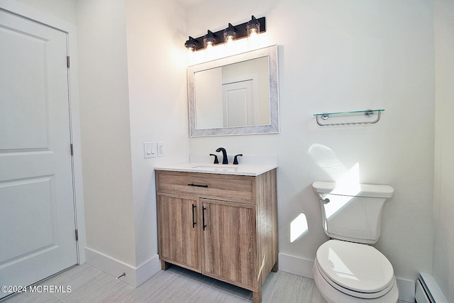 bathroom featuring tile patterned flooring, vanity, toilet, and a baseboard heating unit