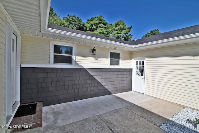 view of exterior entry with a patio