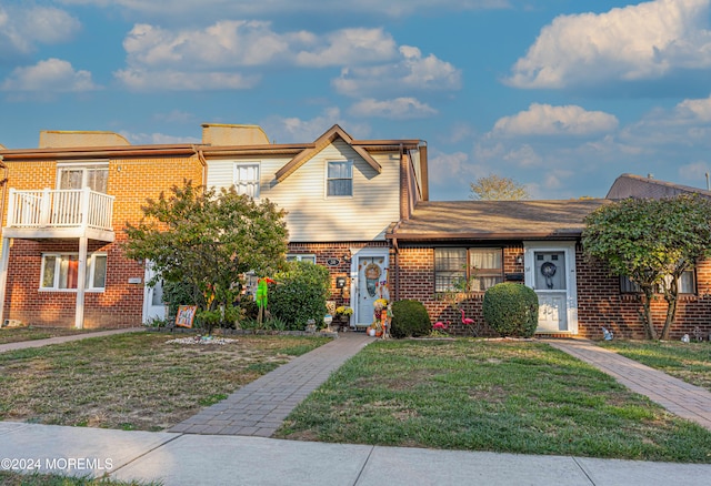 townhome / multi-family property with a front yard