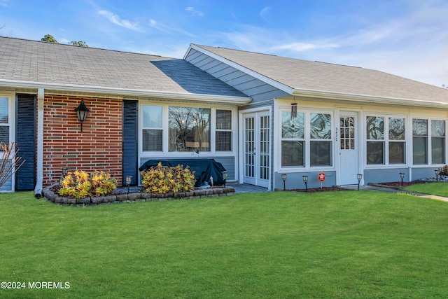 rear view of property with a lawn and french doors