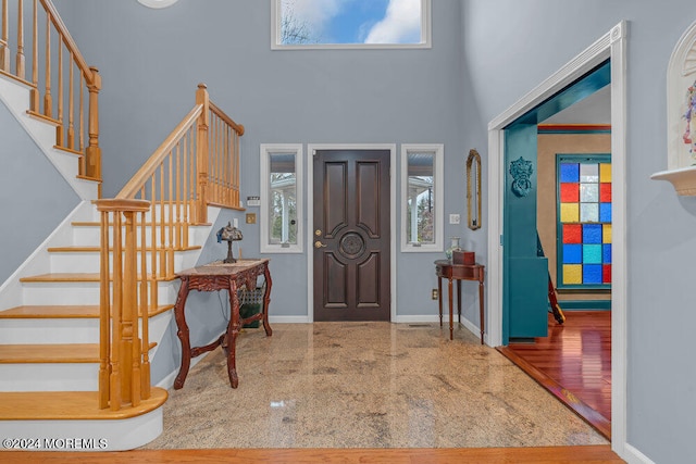 entryway featuring hardwood / wood-style flooring, a healthy amount of sunlight, and a high ceiling