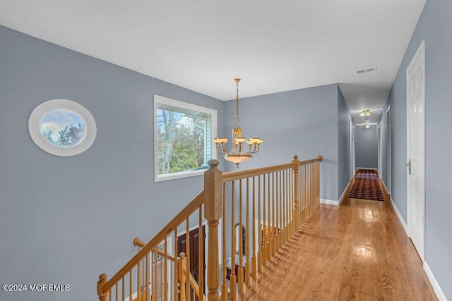 hallway featuring light hardwood / wood-style floors and an inviting chandelier