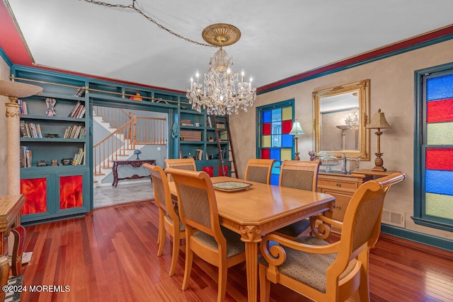 dining area with a chandelier, wood-type flooring, and crown molding