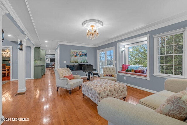 living room with light hardwood / wood-style flooring, ornate columns, and a wealth of natural light