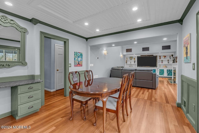 dining area featuring light wood-type flooring, wooden ceiling, and ornamental molding