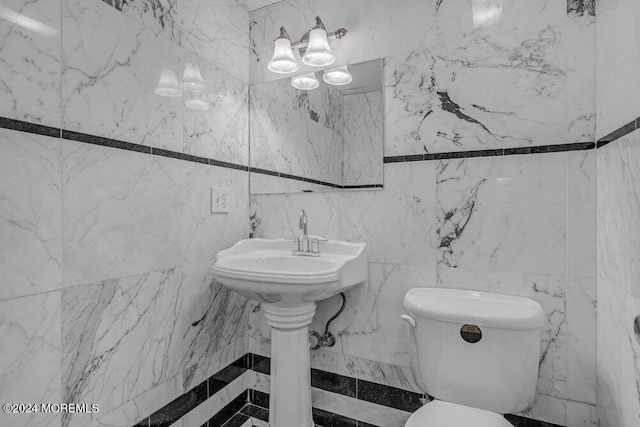 bathroom with toilet and tile walls