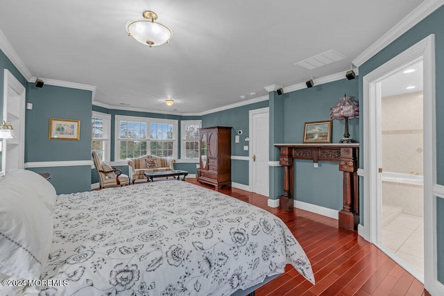 bedroom with dark hardwood / wood-style flooring, ornamental molding, and ensuite bath