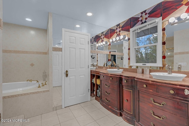 bathroom with vanity, a relaxing tiled tub, tile patterned floors, and tile walls