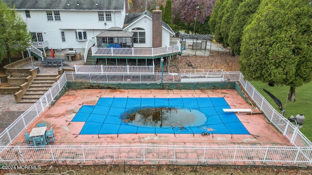 view of pool featuring a diving board and a patio