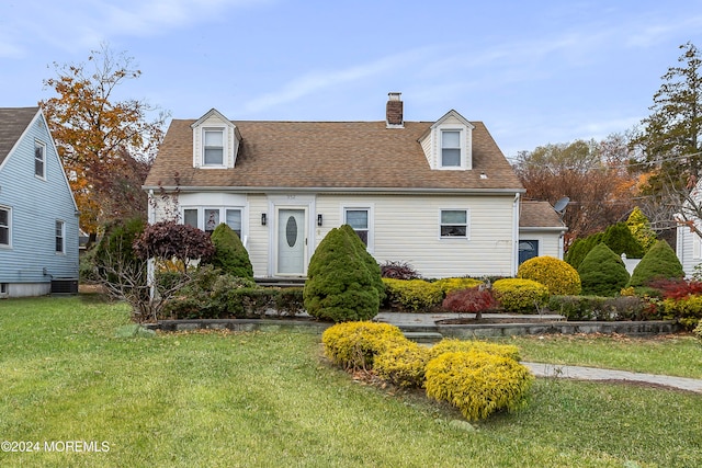 cape cod house featuring central AC and a front yard