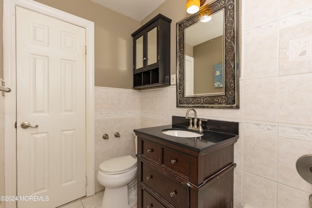 bathroom with tile patterned flooring, vanity, tile walls, and toilet